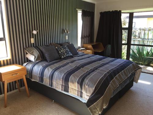 a bedroom with a large bed and a window at Chris's Cabin in Greytown