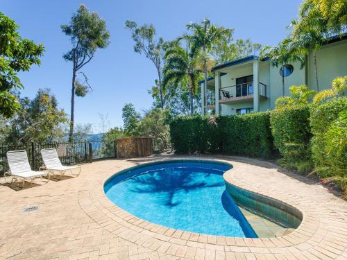 
a swimming pool with a lawn chair in front of it at Compass Point in Hamilton Island
