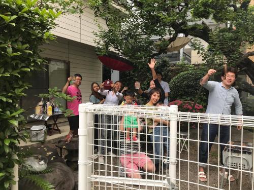 熊本市にあるハッピークローゼット＆ワサモンホステルの塀の後ろに立つ集団