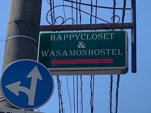 a green street sign on a pole with ahappyclosed and wasseinventhhurst at HappyCloset&WasamonHostel in Kumamoto