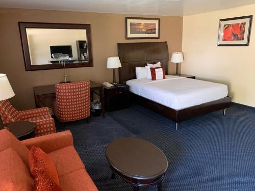 a hotel room with a bed and a couch at Travelodge by Wyndham Rapid City in Rapid City