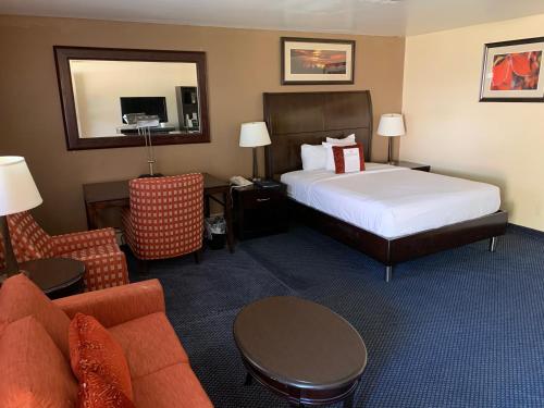 a hotel room with a bed and a couch at Travelodge by Wyndham Rapid City in Rapid City