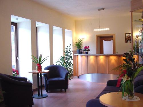 a lobby with a waiting room with chairs and tables at Hotel Kärntnerhof in Mallnitz