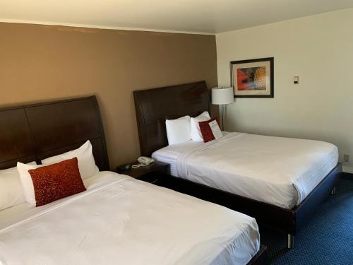 two beds in a hotel room with two beds sidx sidx sidx at Travelodge by Wyndham Rapid City in Rapid City