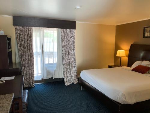 a hotel room with a bed and a window at Travelodge by Wyndham Rapid City in Rapid City