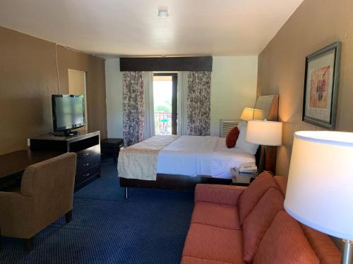 a hotel room with a bed and a television at Travelodge by Wyndham Rapid City in Rapid City