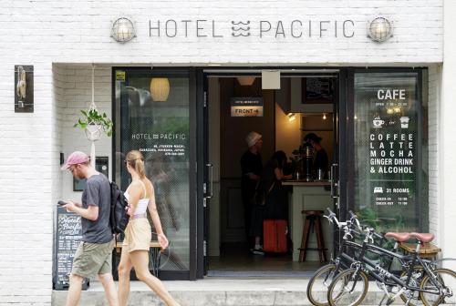 a man and woman walking in front of a store at Hotel Pacific Kanazawa in Kanazawa