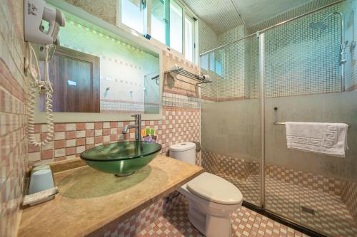 Un baño con un lavabo verde y un inodoro. en 清境英格曼花園民宿, en Renai