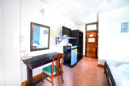 a room with a desk and a mirror and a bed at Pakdee House in Udon Thani