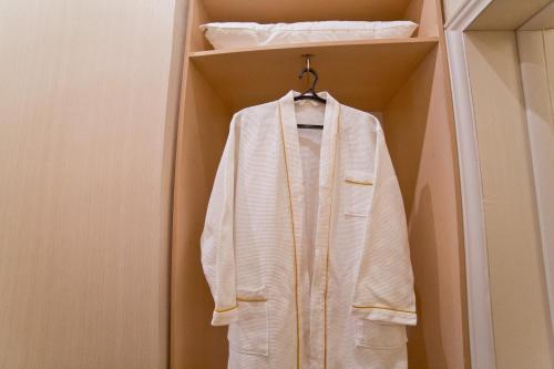 a white coat is hanging in a closet at Aruna Hotel in Astana