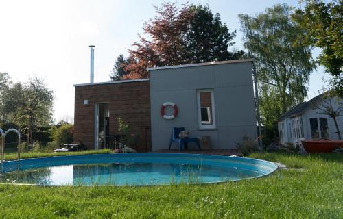a small house with a swimming pool in the yard at Lot Lodge Travemünde in Lübeck