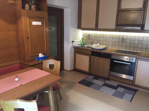 a kitchen with a table and a stove top oven at Ferienhaus Bergfrieden in Sankt Leonhard im Pitztal