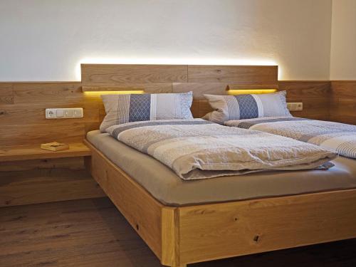 two twin beds in a bedroom with a wooden headboard at Birkholmhof in Bärnau