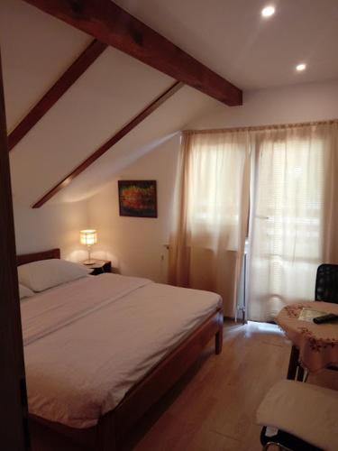 a bedroom with a large bed and a window at Guesthouse Marton in Jezerce