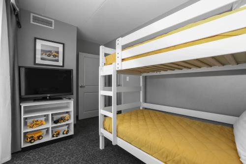 a bedroom with two bunk beds and a flat screen tv at Holiday Inn and Suites East Peoria by IHG in Peoria