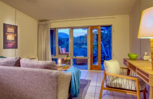 a living room with a couch and a table at Awaroa Lodge in Awa-iti