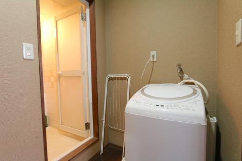 大阪市にあるLiz4 Guest House Liz Nakazakichoのバスルーム(鏡付)の洗濯機と乾燥機
