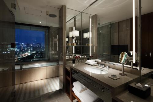 a bathroom with a sink and a large mirror at Palace Hotel Tokyo in Tokyo