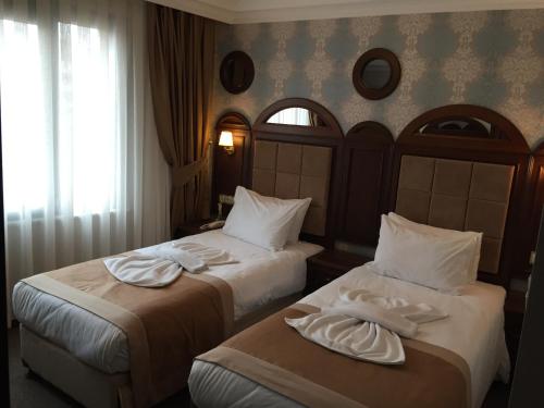 a hotel room with two beds and a window at Golden Pen Hotel in Istanbul