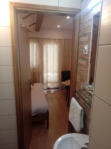 a small bathroom with a sink and a window at Guesthouse Marton in Jezerce