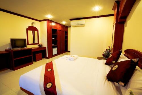 A bed or beds in a room at Baan Sudarat Hotel