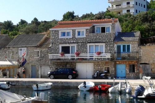 a house with boats in the water in front of it at Apartment Mali Iz 6163a in Iž Mali