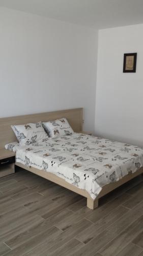 Ce lit se trouve dans une chambre dotée d'un mur blanc. dans l'établissement STUDIO LOTUS, à Mamaia