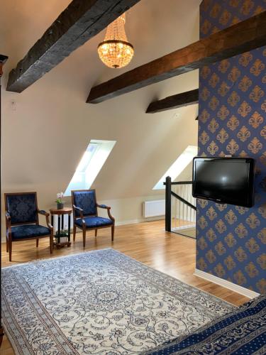 a living room with blue chairs and a tv at Mayfair Hotel Tunneln in Malmö