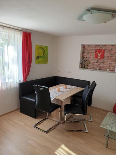 a dining room with a table and black chairs at Ferienwohnung Bleimuth in Passail