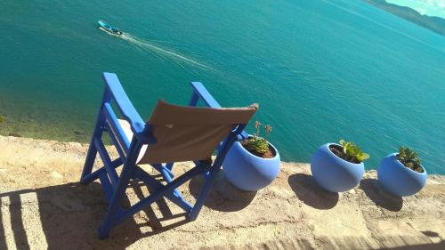 a blue chair sitting next to three potted plants at Linamare Eolos in Kivérion
