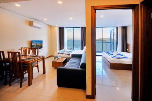 - un salon avec un canapé et une salle à manger dans l'établissement Holi Beach Hotel & Apartments, à Nha Trang