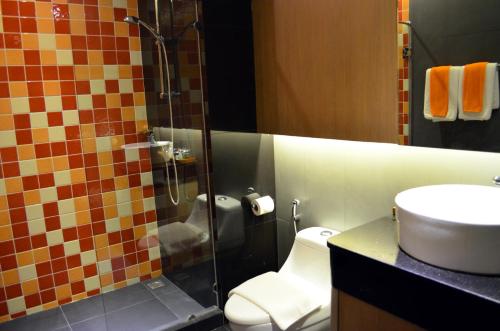 a bathroom with a shower with a toilet and a sink at Tevan Jomtien Pattaya in Jomtien Beach
