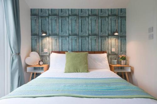 1 dormitorio con 1 cama con cabecero de madera en Walnut Tree Lodge en Aylsham
