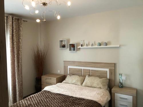 a bedroom with a bed and a chandelier at Apartamento precioso a dos minutos de la playa in Santa Pola