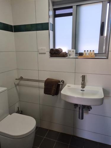 a bathroom with a toilet and a sink at Safari Lodge Motel in Tennant Creek