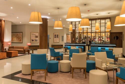 a lobby with blue and white chairs and a bar at Vila Gale Serra da Estrela in Manteigas