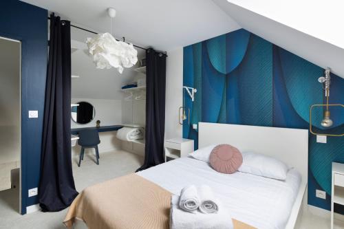 - une chambre avec un lit blanc et des rideaux bleus dans l'établissement Jad'Or - avec parking privé, à Nantes