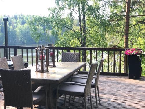 a wooden table and chairs on a deck at Villa Kumpare in Lohja