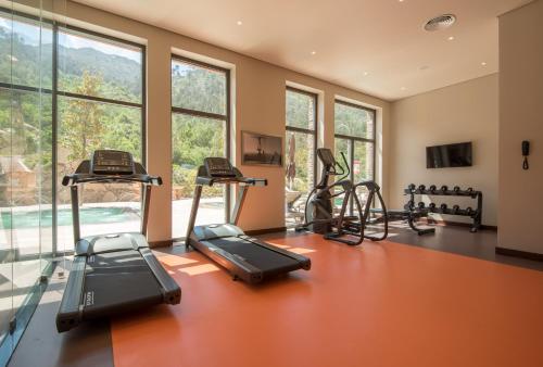 a gym with treadmills and ellipticals in a room with windows at Vila Gale Serra da Estrela in Manteigas