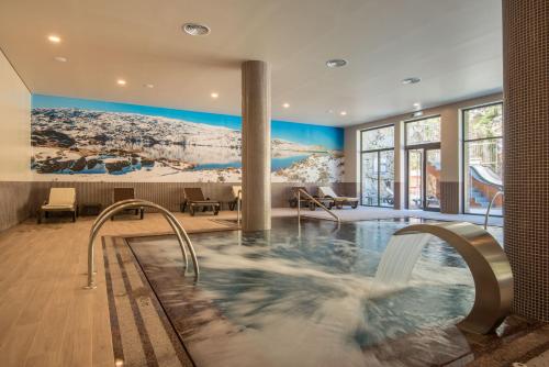 a pool in a hotel room with a hot tub at Vila Gale Serra da Estrela in Manteigas