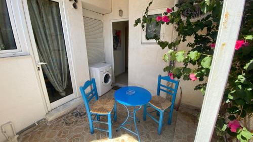 een blauwe tafel en stoelen op de veranda van een huis bij Patras Port apartment in Patra
