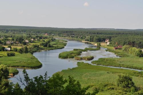 un fiume nel mezzo di una valle con alberi di Maliovnytsya a Dybintsy