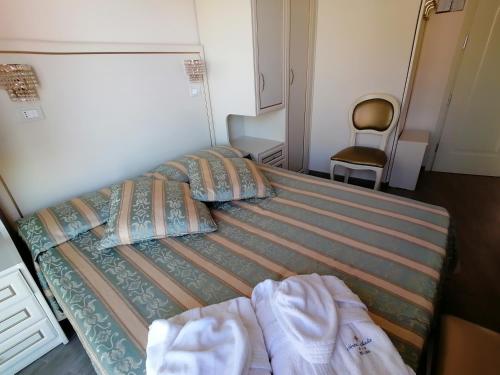 a bedroom with two beds and a chair at Hotel Nordic in Bellaria-Igea Marina