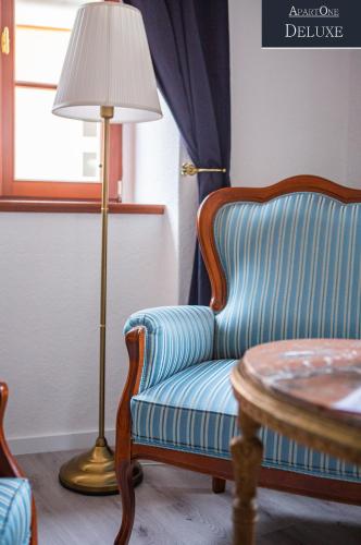 a room with a chair and a lamp and a table at ApartOne Altstadt-Hotel in Bautzen