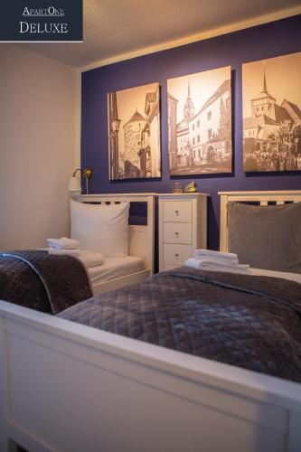 a bedroom with a bed and pictures on the wall at ApartOne Altstadt-Hotel in Bautzen