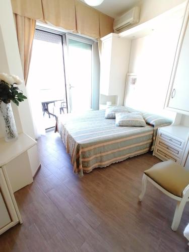 a bedroom with a bed and two large windows at Hotel Nordic in Bellaria-Igea Marina