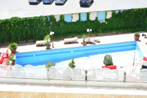 an overhead view of a swimming pool with chairs and plants at Rakeen Hotel in Amman