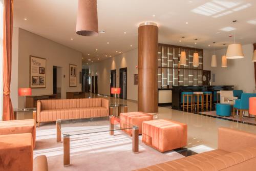 a living room with orange furniture and a lobby at Vila Gale Serra da Estrela in Manteigas