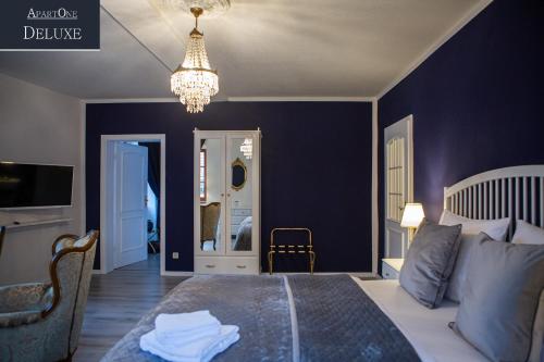 a bedroom with a bed with blue walls and a chandelier at ApartOne Altstadt-Hotel in Bautzen