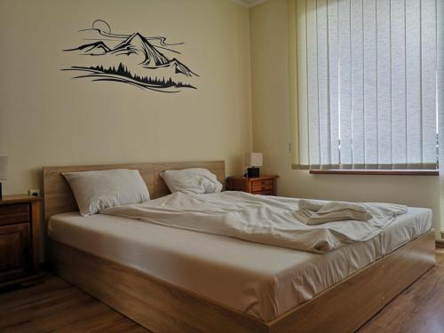 バンスコにあるPine Tree Apartment D34の壁に絵が描かれたベッドルームのベッド1台